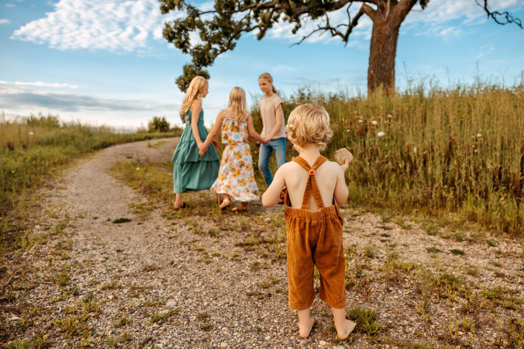 Multiple ages of children playing and having fun outside while at a family photo shoot