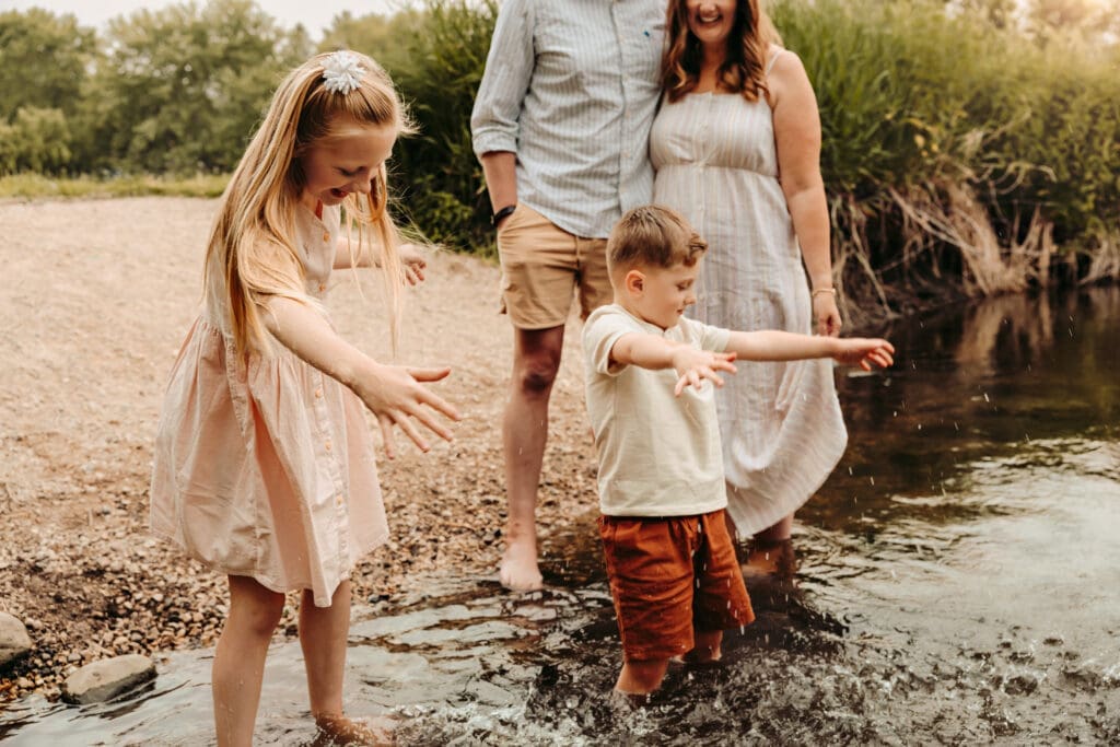 family of 4 playing in the creek during photo session over summer.