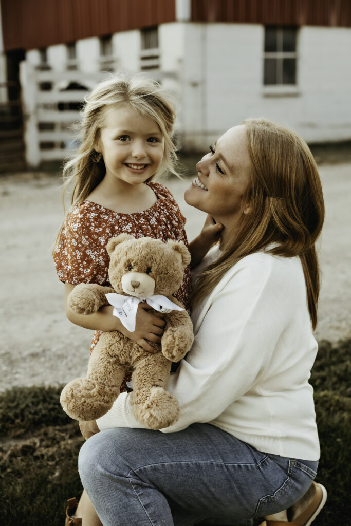 Mom smiling at little girl during a relaxed fall family session in Crystal Lake, Illinois.