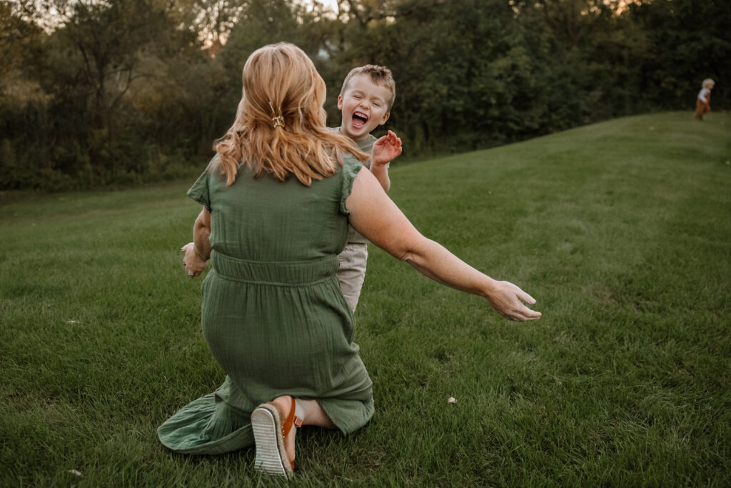 Son running to mom while laughing during a crystal lake family photos session