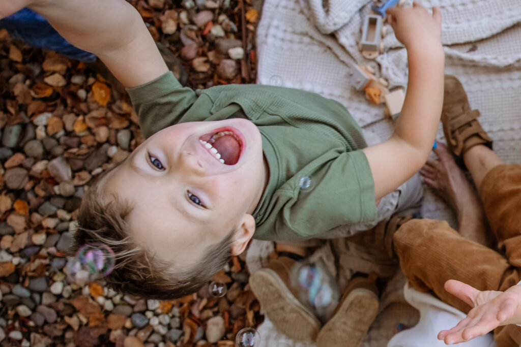 Little boy playing with bubbles during family photos in-home