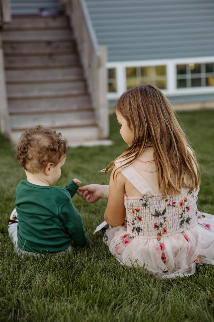 Siblings sharing a snack during an in-home family photo session